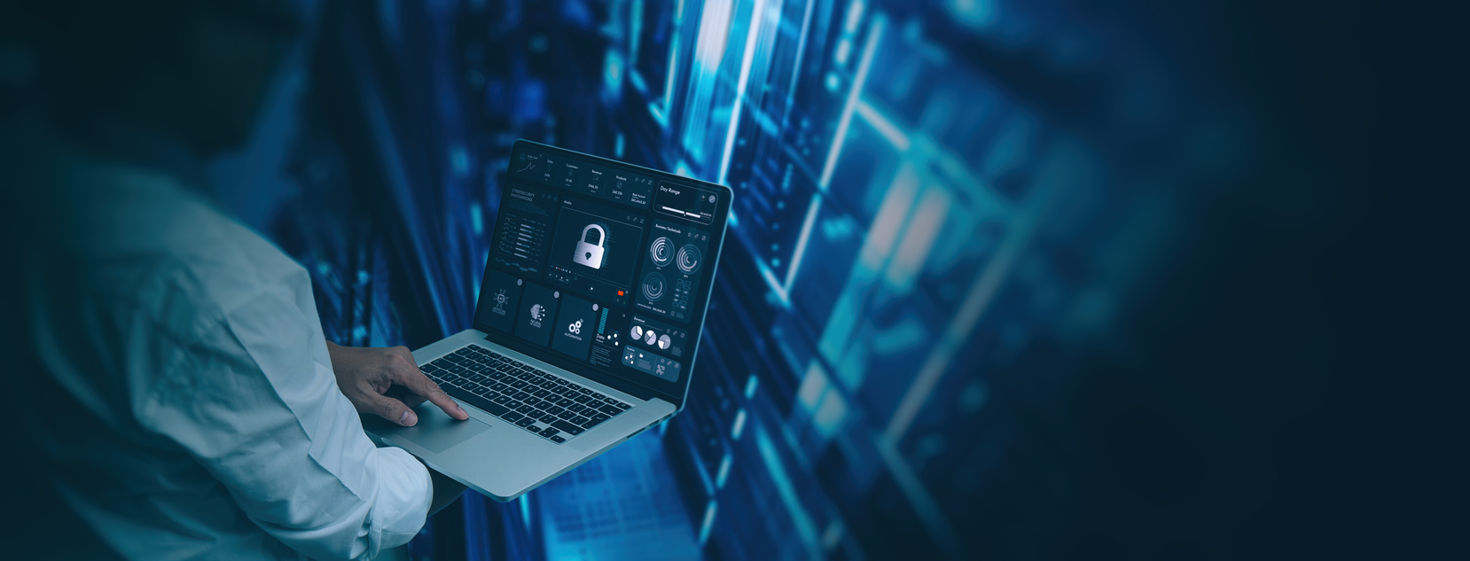 Engineer monitoring network security from a laptop in a data center