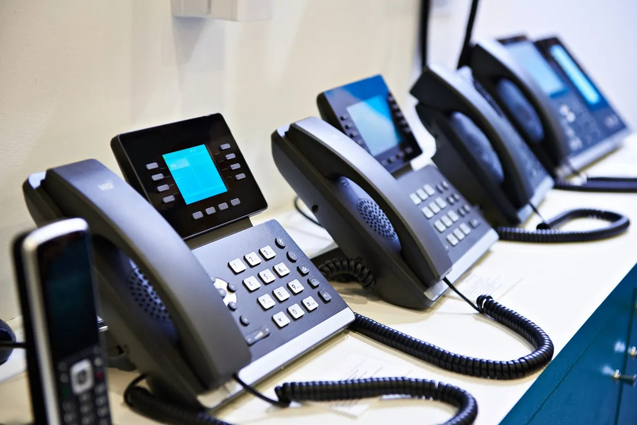 Yealink VoIP desk phones lined up on a shelf