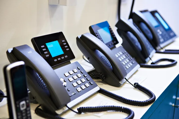 A variety of IP desk phones lined up side by side